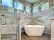 Modern bathroom with a freestanding tub, walk-in shower, beautiful tile work and wood-look floors at 19041 Mardi Gras St, Orlando, FL 32833
