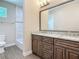 Bathroom showcasing double vanity with granite countertops, a large mirror, and tile flooring at 19041 Mardi Gras St, Orlando, FL 32833