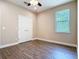 Bright bedroom featuring hardwood floors, neutral walls, and a large window for natural light at 19041 Mardi Gras St, Orlando, FL 32833