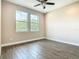 Light and airy bedroom with two windows and wood-look tile flooring at 19041 Mardi Gras St, Orlando, FL 32833