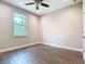 Bedroom with wood-look tile flooring, neutral paint, and natural light at 19041 Mardi Gras St, Orlando, FL 32833