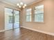 Dining room featuring wood floors, bright windows, and sliding glass door access to a screened in patio with a wooded view at 19041 Mardi Gras St, Orlando, FL 32833