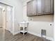 Laundry room with utility sink, gray cabinets, and a tiled floor at 19041 Mardi Gras St, Orlando, FL 32833