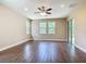 Spacious living room featuring wood-look tile floors, multiple windows, and modern ceiling fan at 19041 Mardi Gras St, Orlando, FL 32833