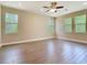 Large living room with wood-look tile flooring, recessed lighting, and natural light through large windows at 19041 Mardi Gras St, Orlando, FL 32833
