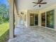 Covered patio with tile flooring, ceiling fans, and sliding glass doors overlooking the green backyard at 19041 Mardi Gras St, Orlando, FL 32833