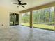 Expansive covered patio with tile flooring, ceiling fans, and views of the wooded backyard at 19041 Mardi Gras St, Orlando, FL 32833