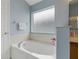 Bright bathroom featuring a soaking tub under a privacy window at 2576 Boots Rd, Lakeland, FL 33810