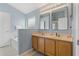 Bathroom featuring light blue walls, double sinks, two framed mirrors, and a bathtub at 2576 Boots Rd, Lakeland, FL 33810