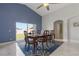 A blue dining room features a large wooden table, chairs, and a view of the backyard at 2576 Boots Rd, Lakeland, FL 33810