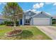Single-story home featuring a tidy lawn, two car garage, and inviting blue front door at 2576 Boots Rd, Lakeland, FL 33810
