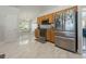A spacious kitchen featuring stainless steel appliances, wood cabinets, and sleek, modern flooring at 2576 Boots Rd, Lakeland, FL 33810