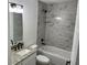 Elegant bathroom features modern fixtures, granite vanity, and tiled shower-tub combination at 5635 Nw 61St Ct, Ocala, FL 34482