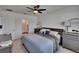 Comfortable bedroom featuring a queen-sized bed with neutral bedding, a ceiling fan, and a view of the ensuite bathroom at 3628 Diving Dove Ln, Bartow, FL 33830