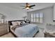 Comfortable bedroom featuring a queen-sized bed with neutral bedding, a ceiling fan, and plantation shutters at 3628 Diving Dove Ln, Bartow, FL 33830