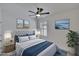 Bright bedroom featuring a tufted headboard bed with side tables, lamps, beach themed prints, and plantation shutters at 3628 Diving Dove Ln, Bartow, FL 33830