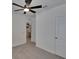A bedroom with a ceiling fan features light grey carpet, and multiple white doors at 3628 Diving Dove Ln, Bartow, FL 33830