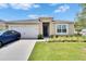 Charming single-story home with a two-car garage, manicured lawn, and inviting front entrance at 3628 Diving Dove Ln, Bartow, FL 33830