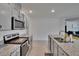 Stylish kitchen featuring granite countertops, stainless steel appliances, and gray cabinetry at 3628 Diving Dove Ln, Bartow, FL 33830