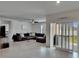 Spacious living room with a large sectional sofa, neutral color palette, and sliding glass doors to the outside at 3628 Diving Dove Ln, Bartow, FL 33830