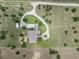 An aerial view of a home featuring a curved driveway and neatly maintained landscaping, surrounded by open land at 9419 Alturas Babson Park Cutoff Rd, Bartow, FL 33830