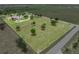 Aerial view of the expansive property, showcasing the home, garage, and surrounding acreage at 9419 Alturas Babson Park Cutoff Rd, Bartow, FL 33830