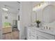Bright bathroom connecting to bedroom with dual sinks and elegant mirrors at 9419 Alturas Babson Park Cutoff Rd, Bartow, FL 33830