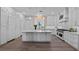 Spacious kitchen with an island, white cabinetry, modern appliances, and pendant lighting at 9419 Alturas Babson Park Cutoff Rd, Bartow, FL 33830