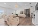 Bright living room featuring a stunning chandelier, hardwood floors, and comfortable seating at 9419 Alturas Babson Park Cutoff Rd, Bartow, FL 33830