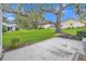 Backyard featuring a mature tree and a concrete patio, perfect for outdoor enjoyment at 5402 Rosewall Cir, Leesburg, FL 34748