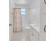 Bright bathroom features a shower-tub combination with a decorative shower curtain at 5402 Rosewall Cir, Leesburg, FL 34748