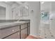 Bathroom featuring dual mirrors over the vanity and an entrance to the tub area at 5402 Rosewall Cir, Leesburg, FL 34748