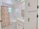 Bright bathroom features a shower-tub combination with a decorative shower curtain and white cabinets at 5402 Rosewall Cir, Leesburg, FL 34748