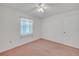 Cozy bedroom features a ceiling fan, a window and carpet flooring at 5402 Rosewall Cir, Leesburg, FL 34748