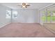 Spacious bedroom with neutral carpet, ceiling fan, and sliding glass doors to a sunroom at 5402 Rosewall Cir, Leesburg, FL 34748