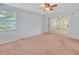 Neutral bedroom with a ceiling fan, and sliding glass doors to a sunroom at 5402 Rosewall Cir, Leesburg, FL 34748