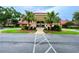 Exterior of the community clubhouse featuring a porte-cochere entry and palm trees at 5402 Rosewall Cir, Leesburg, FL 34748