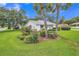 This beautiful home showcases lush landscaping with mature palm trees and flowering bushes at 5402 Rosewall Cir, Leesburg, FL 34748