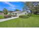 Well-maintained home with a green lawn, mature shade tree, and manicured shrubbery at 5402 Rosewall Cir, Leesburg, FL 34748