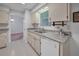 Well-lit kitchen with white appliances, tile flooring, and views of the dining area at 5402 Rosewall Cir, Leesburg, FL 34748