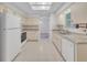 Functional kitchen layout featuring white appliances, tile flooring, and ample countertop space at 5402 Rosewall Cir, Leesburg, FL 34748