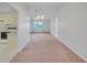 Open living room with pink carpet that seamlessly flows to the kitchen featuring a ceiling fan at 5402 Rosewall Cir, Leesburg, FL 34748