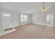 Bright living room with a ceiling fan, large window, neutral carpet and a tiled entrance at 5402 Rosewall Cir, Leesburg, FL 34748