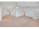 Open living space with neutral walls and carpet, featuring a ceiling fan and multiple entryways at 5402 Rosewall Cir, Leesburg, FL 34748