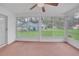 Bright sunroom featuring large windows overlooking the green lawn and a ceiling fan at 5402 Rosewall Cir, Leesburg, FL 34748