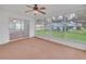Bright sunroom with large windows offering views of the lush backyard and a ceiling fan at 5402 Rosewall Cir, Leesburg, FL 34748