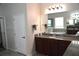 Bathroom with granite countertops, wooden cabinets, and a soaking tub below a bright window at 1319 Heavenly Cv, Winter Park, FL 32792