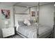 Bright bedroom with a modern four-poster bed, unique artwork, and an ensuite bathroom at 1319 Heavenly Cv, Winter Park, FL 32792