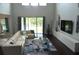 Spacious living room with high ceilings, a comfortable sectional sofa, and large windows overlooking the backyard at 1319 Heavenly Cv, Winter Park, FL 32792