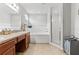 Bright bathroom featuring double sinks, wood cabinets, a soaking tub, and walk-in shower at 2053 Charleston Ln, Bartow, FL 33830